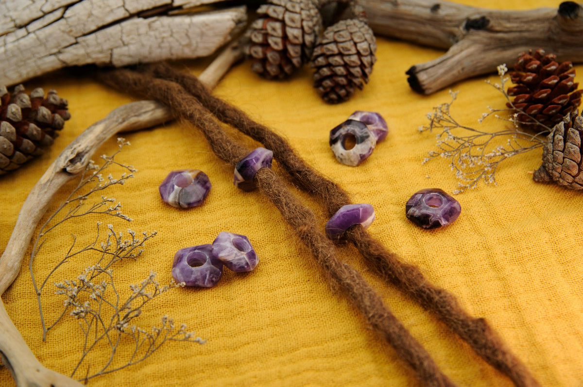 Große Amethyst-Scheibenperlen an Dreads auf gelbem Stoff