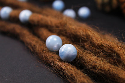Runde hellblaue Aquamarin-Dreadlockperlen an braunen Dreads